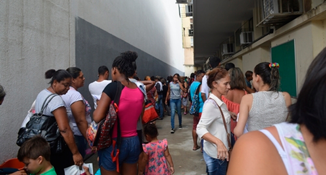 Pais sofrem na fila de posto de saúde para conseguirem vacina pentavalente em Nova Iguaçu